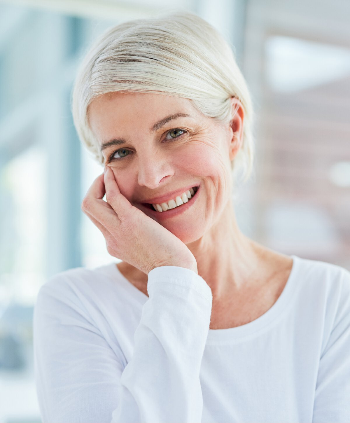 Los Angeles neck lift model smiling and holding her face